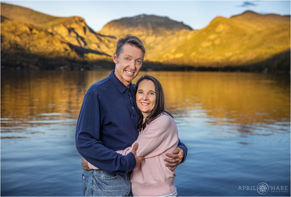 A couple pose for a portrait in front of the Grand Lake Colorado Mountain view at Point Park