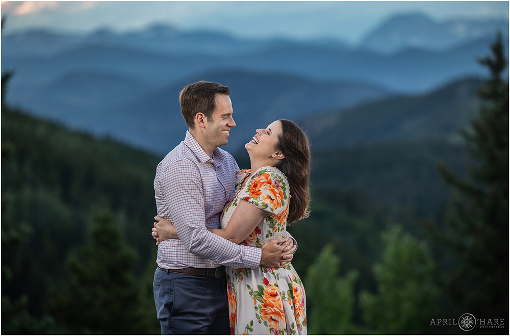 Couple laugh together with a beautiful mountain backdrop on Squaw Pass Road in Colorado
