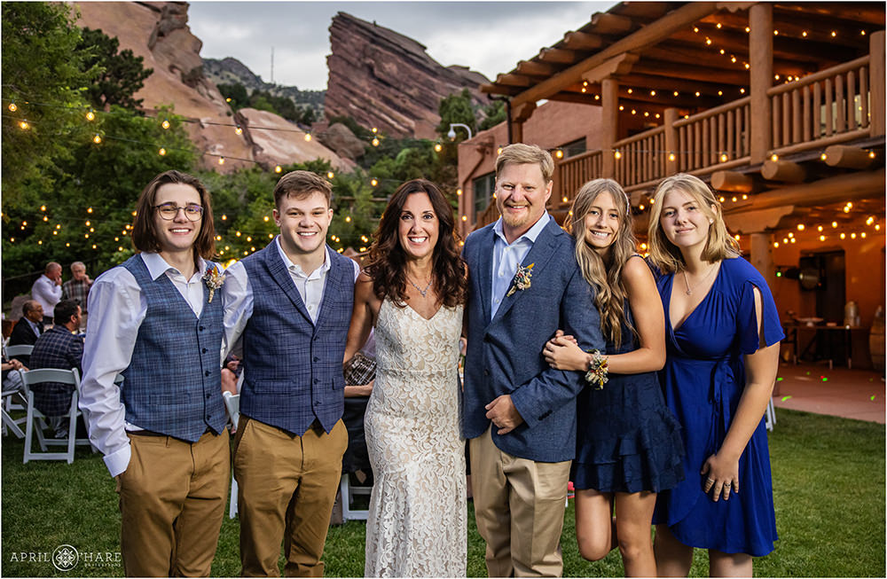 Bride and groom pose for a photo at their reception with their kids at Red Rocks