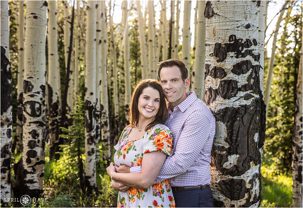 Couple pose for a portrait together in the forest in an aspen tree forest on Squaw Pass Road in Colorado