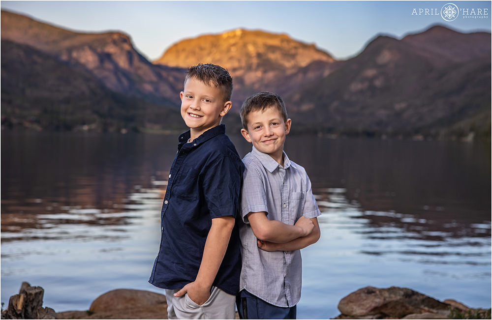 Two brothers standing back to back in front of Grand Lake Mountain view at Point Park Colorado