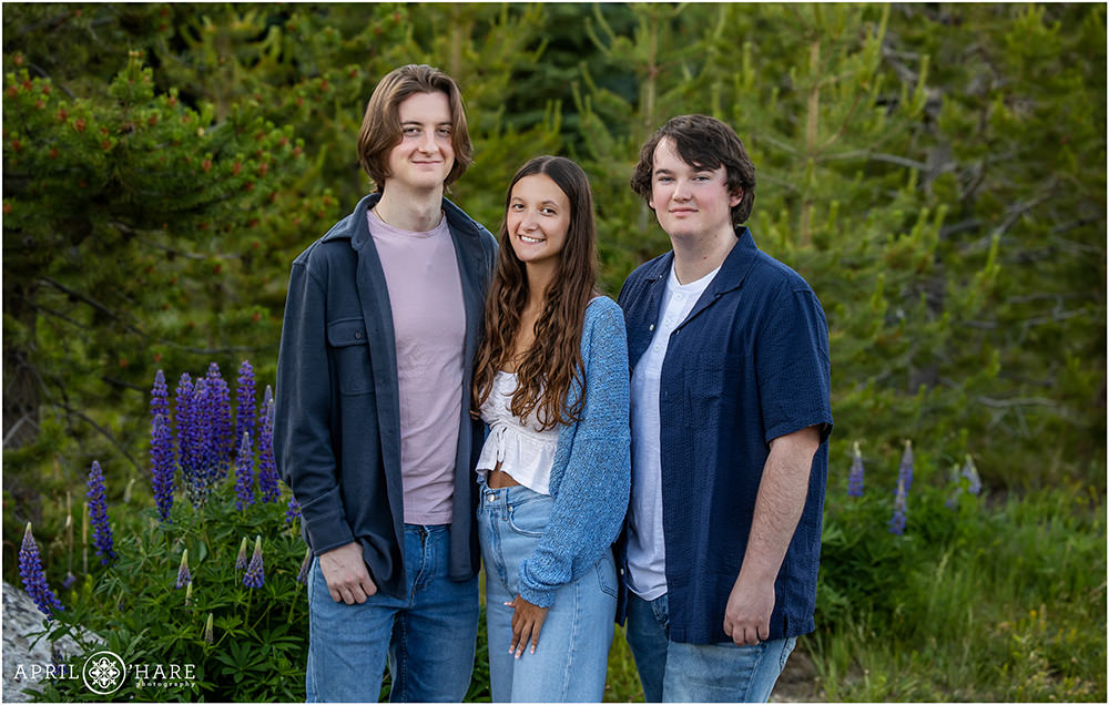 3 young adult siblings pose in a pretty mountain garden at Point Park in Grand Lake Colorado