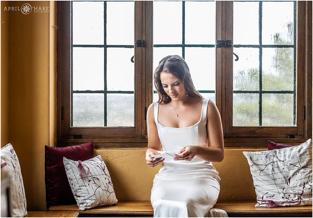 Bride has a moment to herself to read a note from her groom at Cherokee Ranch and Castle in Colorado