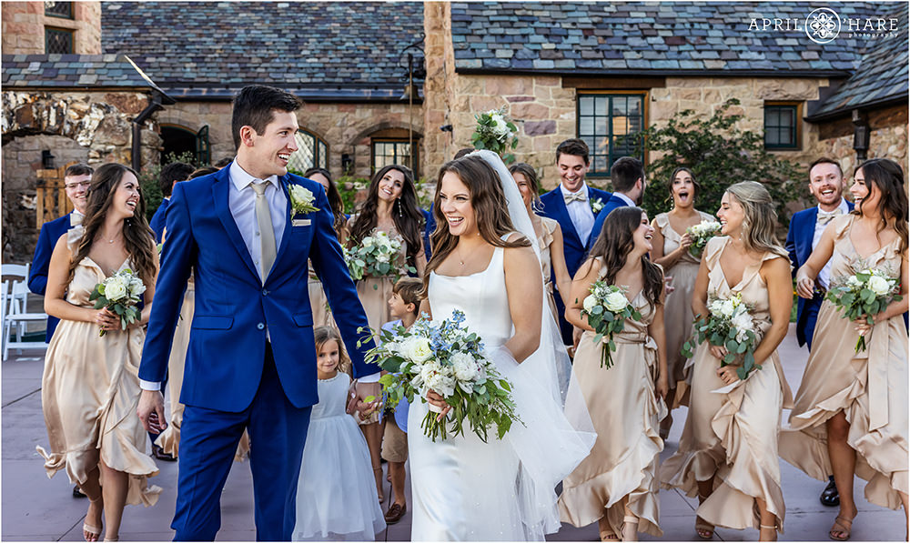 Candid moment of bride and groom walking with their wedding party in the Courtyard of Cherokee Ranch and Castle