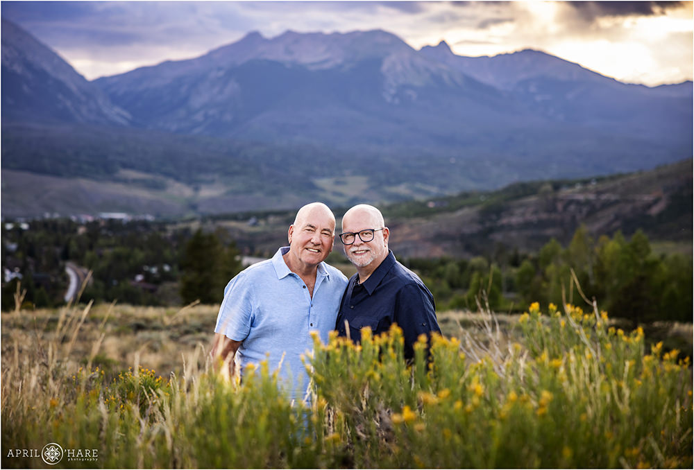 Cute photo of an older gay couple posing with a beautiful mountain backdrop in Colorado