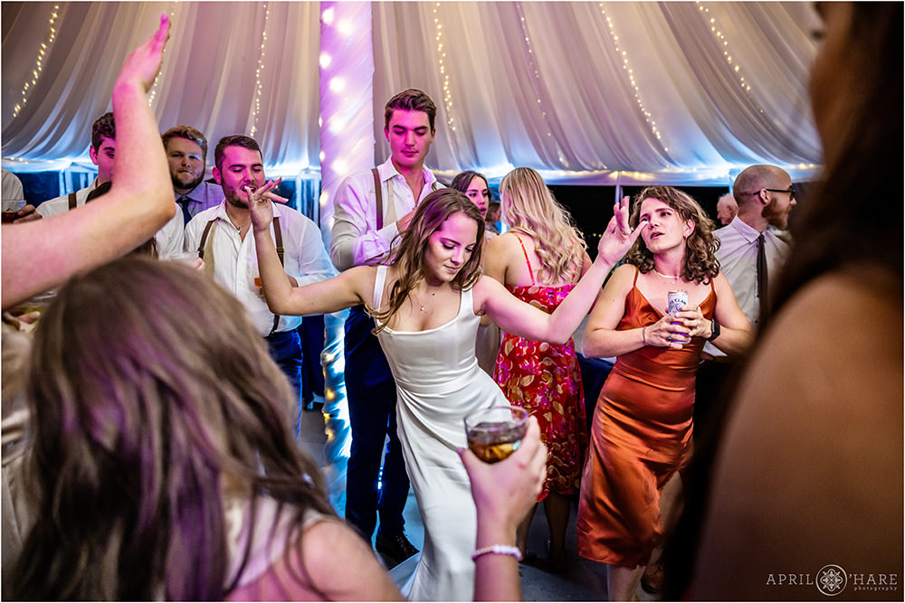 Bride busts a dance move in a tent wedding reception in Colorado