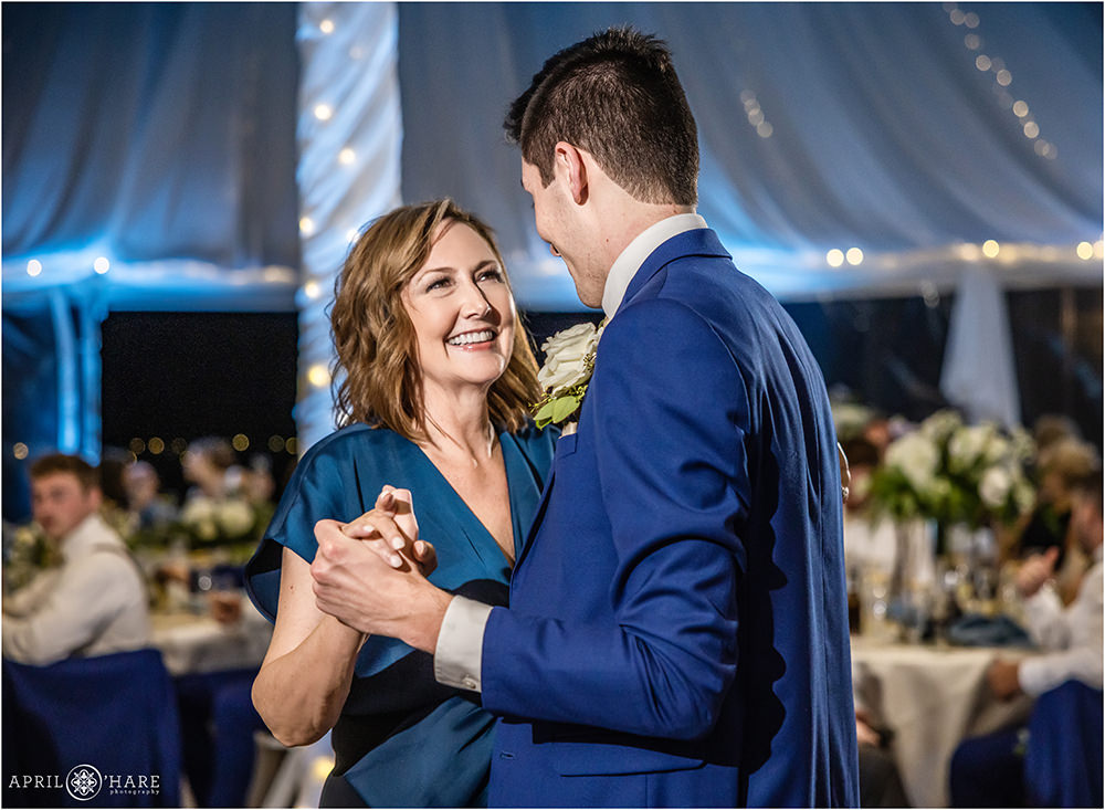 Mom smiles at her son during the mother son dance at his Colorado wedding