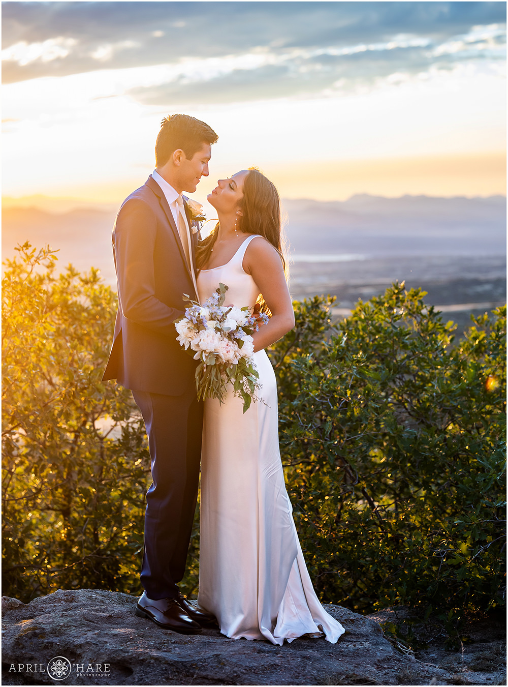 Warm glowing light on bride and groom as the sun sets at their castle wedding in Colorado