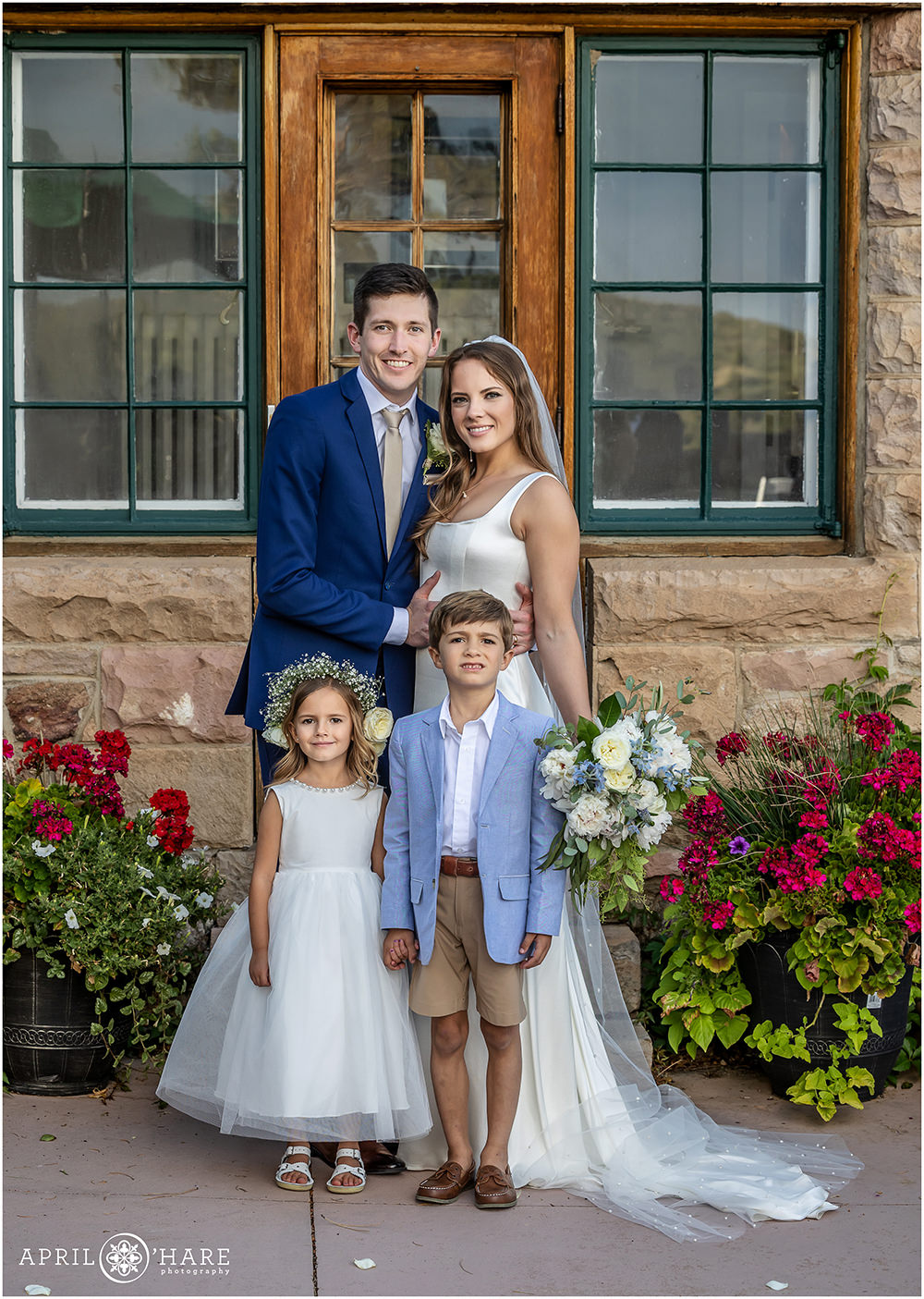 Bride and groom pose with the ring bearer and flower girl in the Castle Courtyard