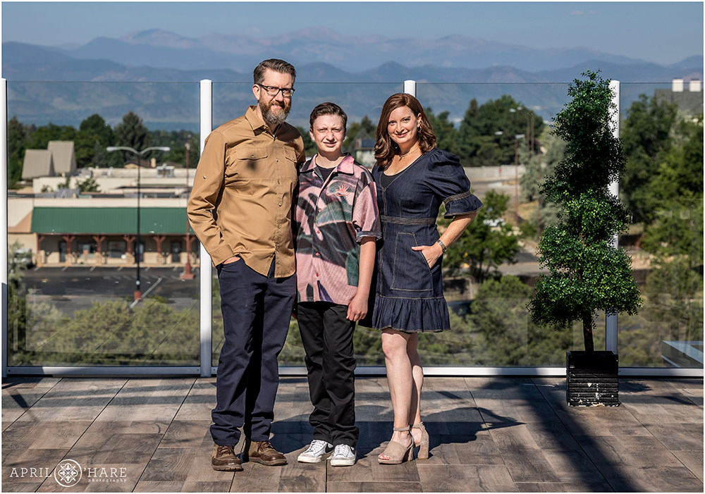 Parents of bar mitzvah boy pose for a portrait with him on the rooftop deck