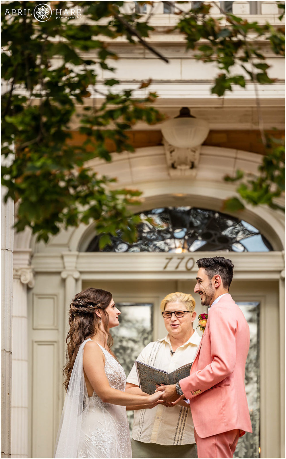 Vertical photo of bride and groom looking into each other's eyes on front steps of Grant Humphreys Mansion during their summer wedding ceremony