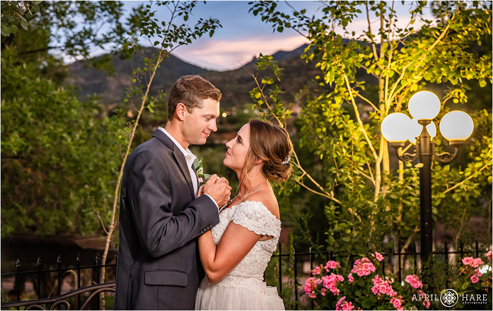 Romantic portrait of Bride and groom gazing into each other's eyes with a mountain backdrop at Craftwood Inn Patio During Summer
