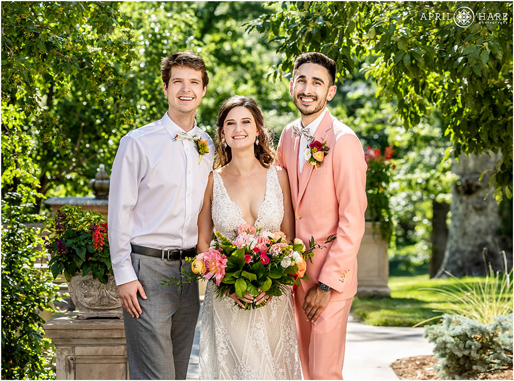 Bride and her groom get a photo with the bride's brother on their wedding day at Grant Humphreys Mansion in Denver
