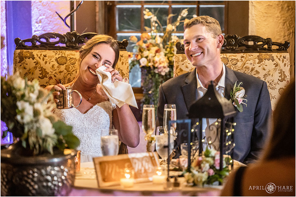 Bride and groom laugh during the speeches at their Craftwood Inn Wedding Reception