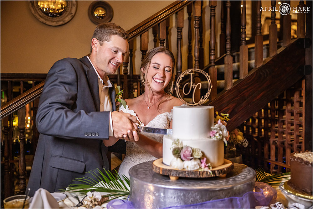 Bride and groom cut their cake at the Craftwood Inn at their summer wedding day in Manitou Springs
