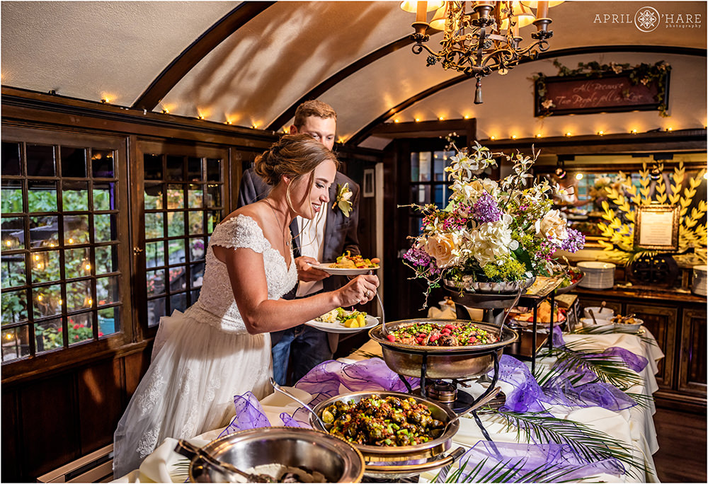 Bride and groom load up their plates with delicious food at Craftwood Inn on their wedding day