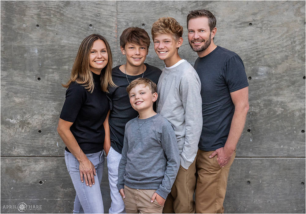 Family pose in front of a gray wall outside of the Denver Botanic Gardens in Colorado