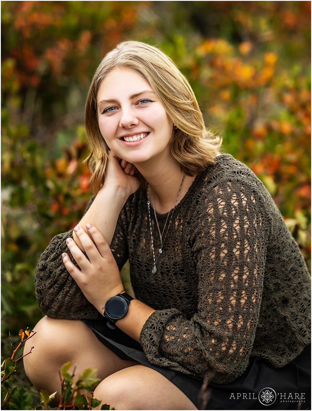 Senior picture with a young lady wearing a green crocheted sweater in the fall colors of South Mesa Trail