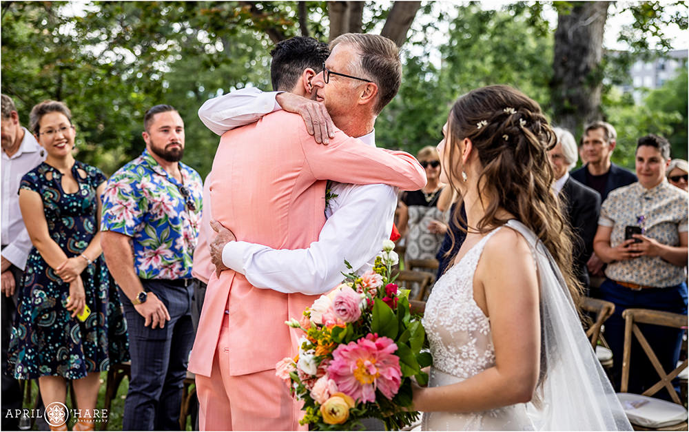 Groom hugs is father in law after he walks his bride down the aisle at Grant-Humphreys Mansion in Denver
