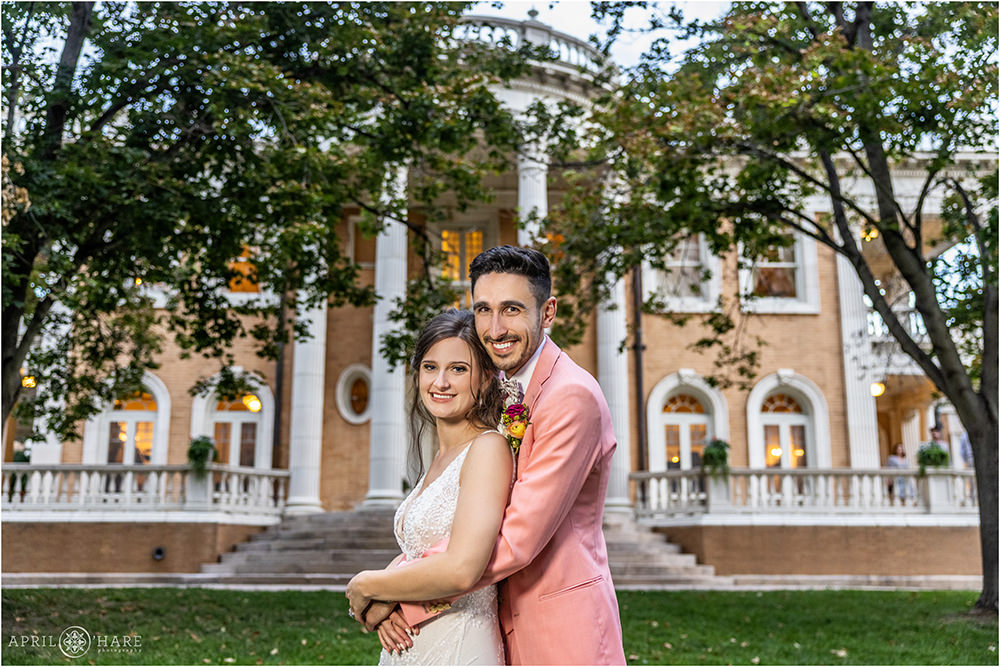 Bride and groom pose for a classic portrait in front of the Grant-Humphreys Mansion at sunset