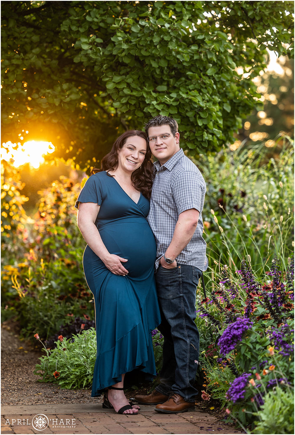 Couple expecting their 2nd child are photographed in a gorgeous sunset garden setting for their maternity portraits