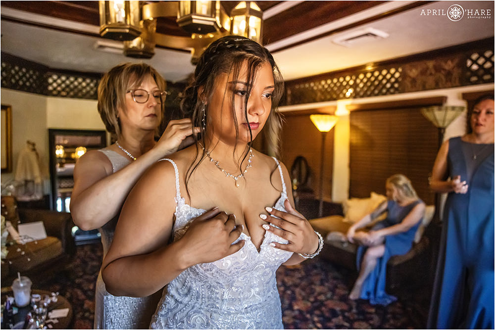 Bride's mom helps her with her necklace at Wellshire Event Center