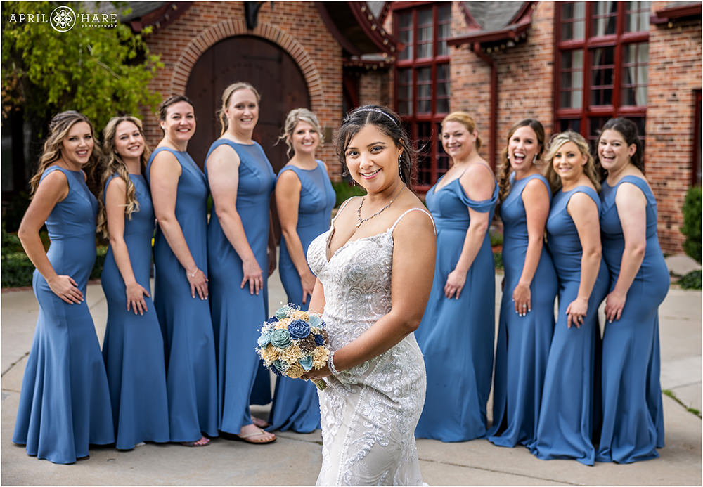 Bride portrait with her bridesmaids laughing behind her at Wellshire Event Center