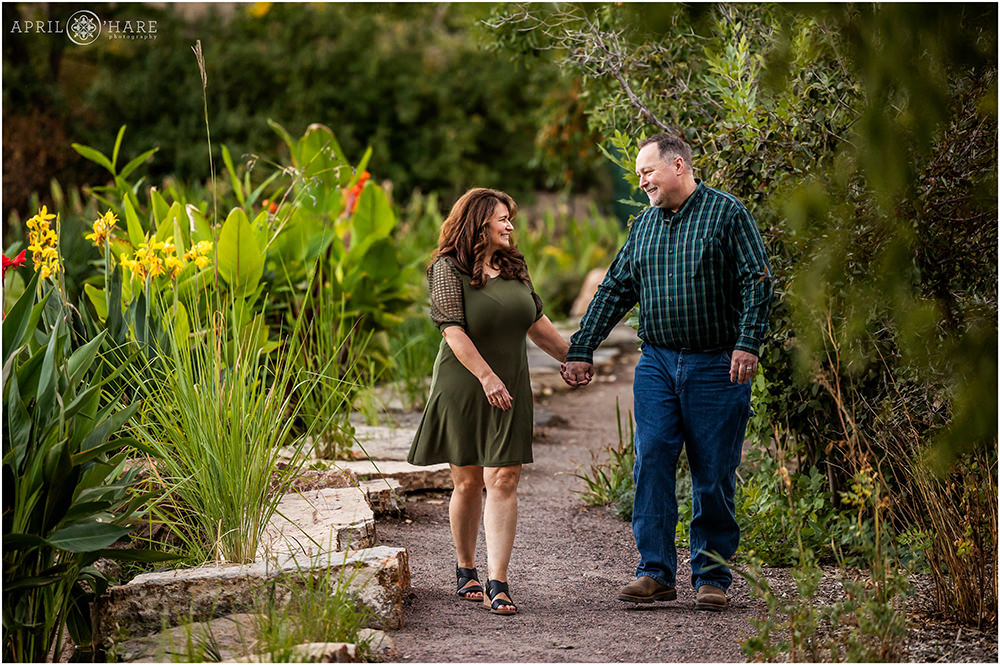 Couple walk hand in hand down a garden path next to a water lily garden at Hudson Gardens