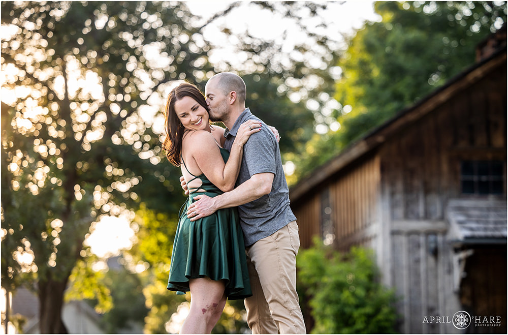 Sweet snuggly couples portrait with a pretty barn backdrop at Heritage Lakewood Belmar Park