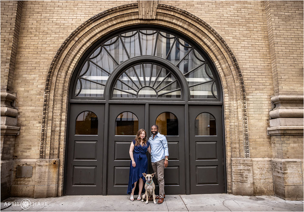 A couple with their sweet dog in front of a pretty arched doorway at the Denver Center for Performing Arts Complex in downtown Denver