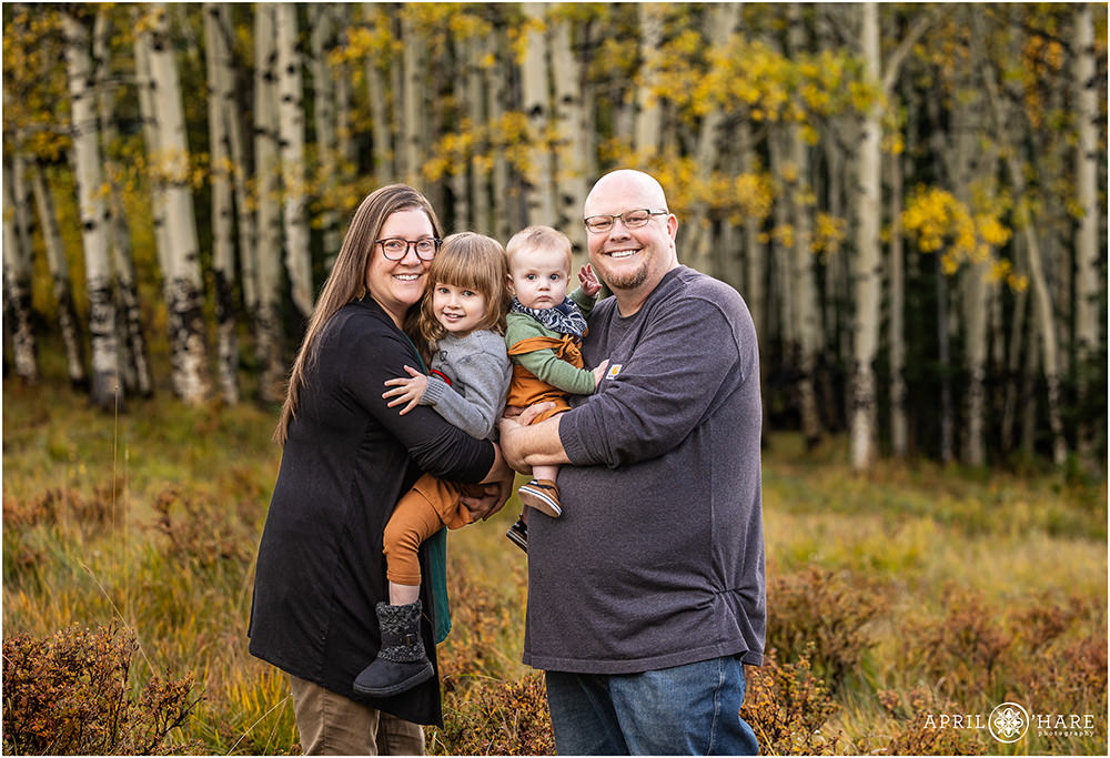 Sweet fall color family portraits with aspen tree backdrop in Evergreen Colorado