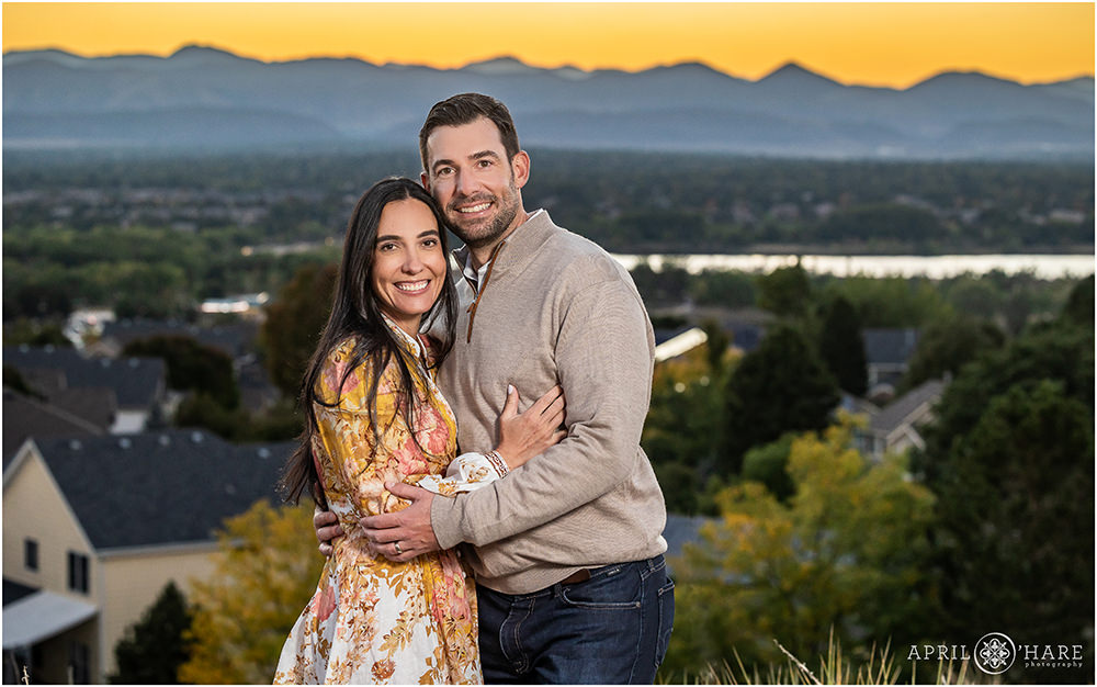Married couple get a photo in front of the pretty mountain backdrop at Sunset at Jackass Hill in Littleton
