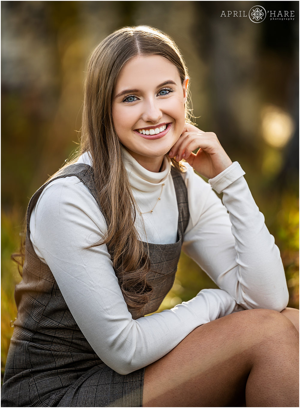 Classic high school yearbook senior portraits for a girl wearing a jumper with long sleeve white turtleneck in a fall color forest in Colorado