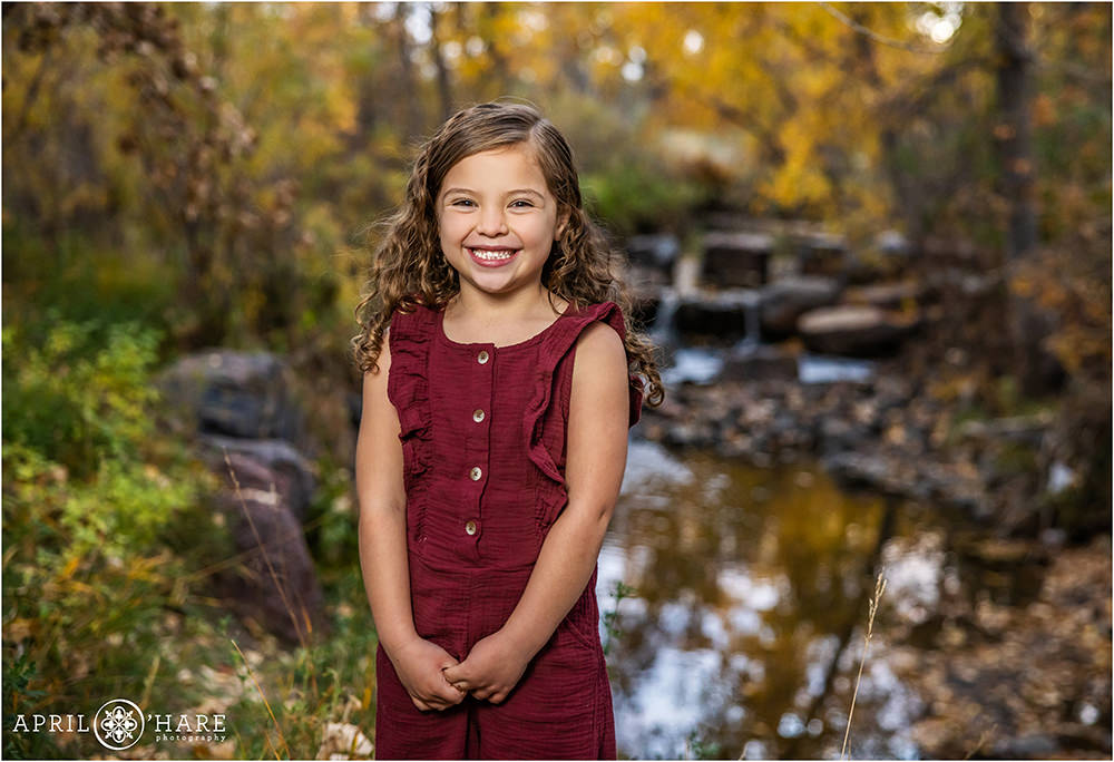 Cute girl in front of a small waterfall backdrop during Autumn at James Bible Park