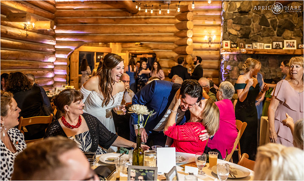 Sweet moment of the couple going around to the tables at their wedding reception and interacting with guests at the Evergreen Lake House