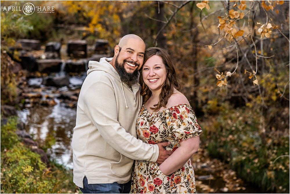 Couples portrait with pretty fall color waterfall backdrop at James Bible Park in Denver