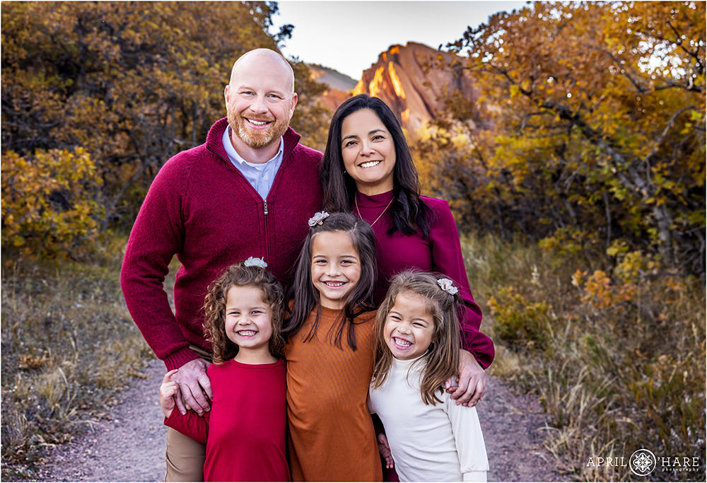 Family of 5 with 3 young girls laugh together at Roxborough State Park During Autumn