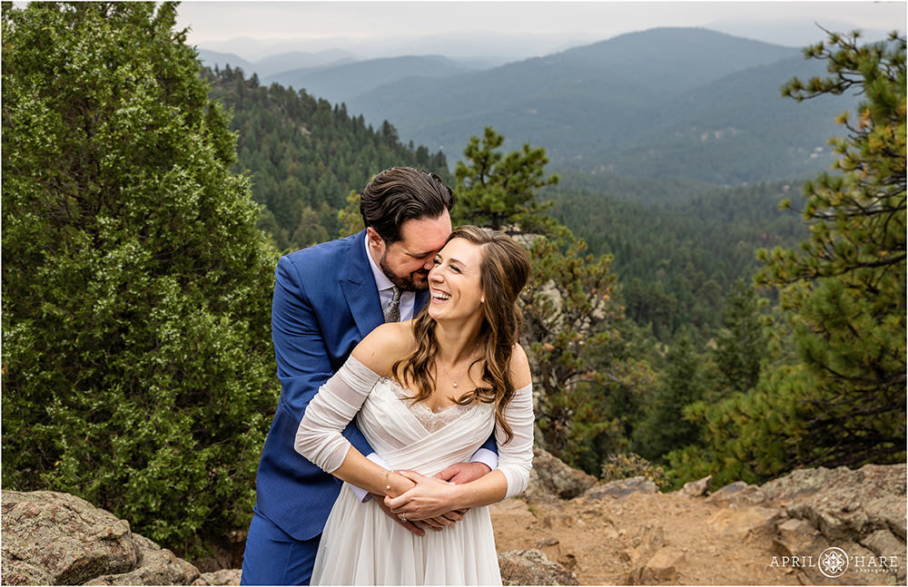 Couple snuggle with a beautiful mountain backdrop at West Mount Falcon Trailhead