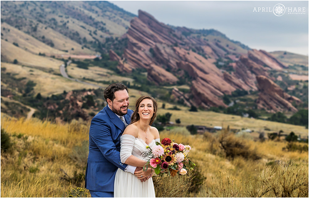 Couple laugh together with Red Rocks in the backdrop at the East Mount Falcon Trailhead in Morrison