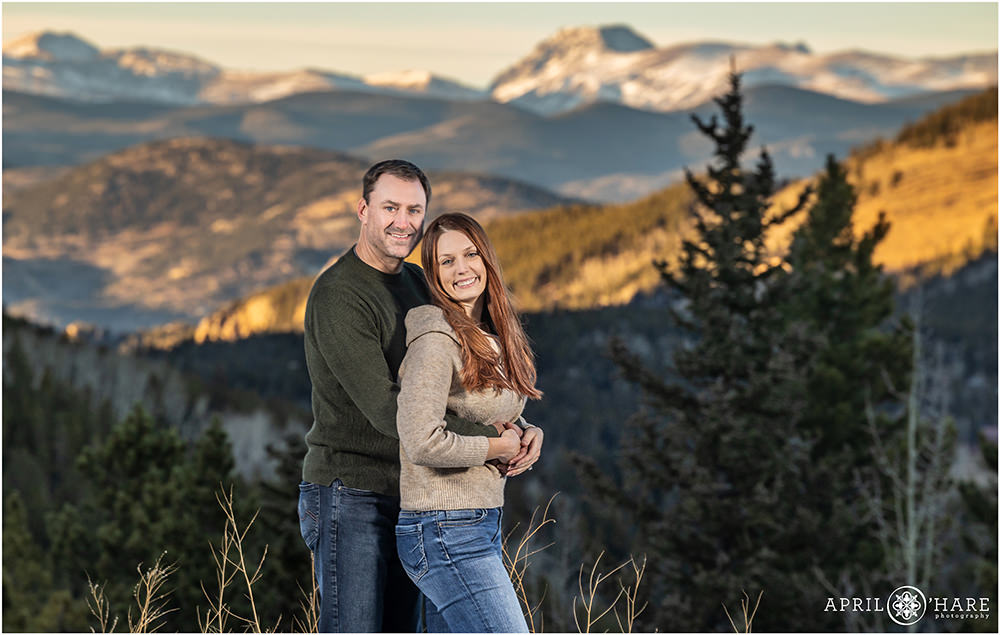 Engaged couple photographed with a pretty mountain backdrop in Evergreen CO
