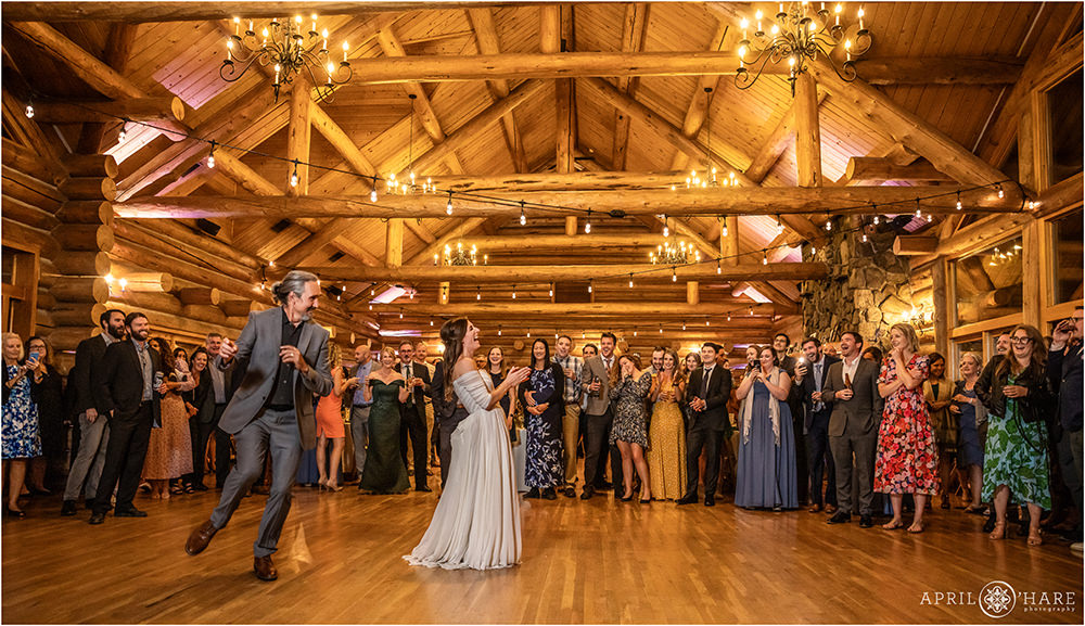 Bride laughs as her dad dances wildly around her at the Evergreen Lake House in Colorado