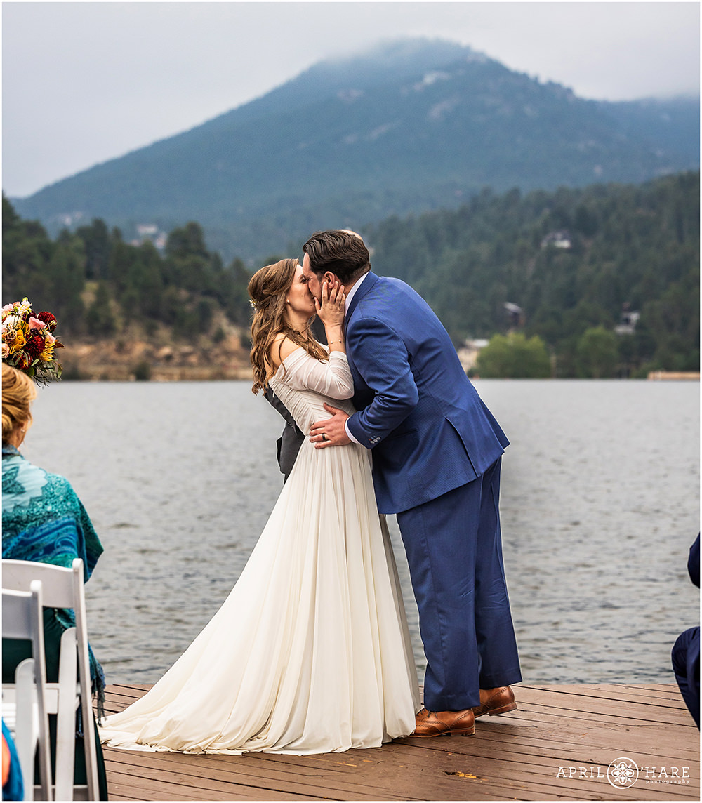 Bride and groom kiss at the end of their wedding ceremony at Evergreen Lake House