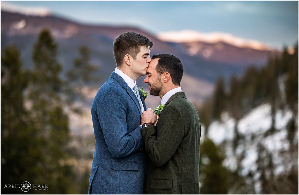 Groom kisses his husband on his forehead at sunset at Sapphire Point