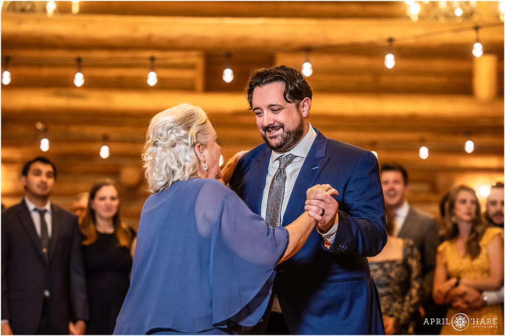 Groom smiles at his mom as they dance together at the Evergreen Lake House