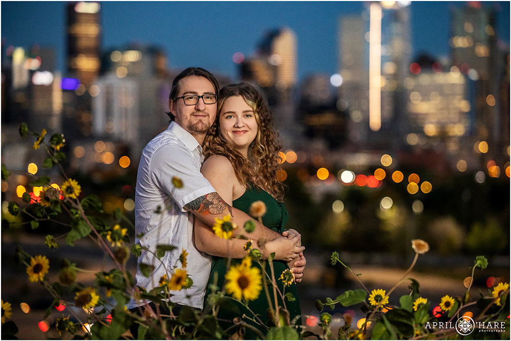 Denver couples portrait with the Denver Skyline with cute sunflowers in the foreground