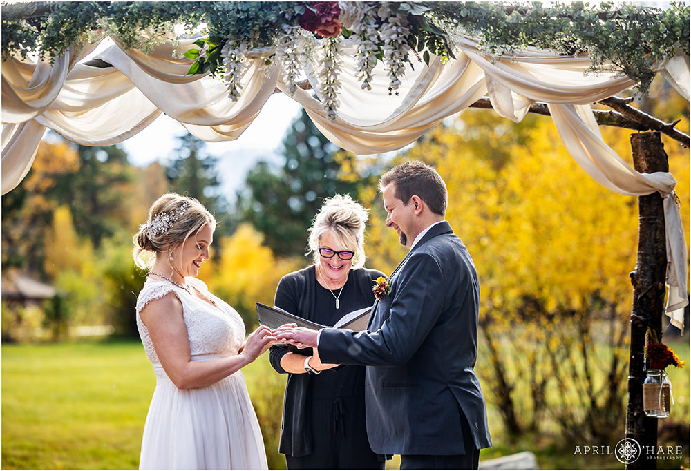 Bride and groom exchange rings at Romantic Riversong Inn in Estes Park Colorado