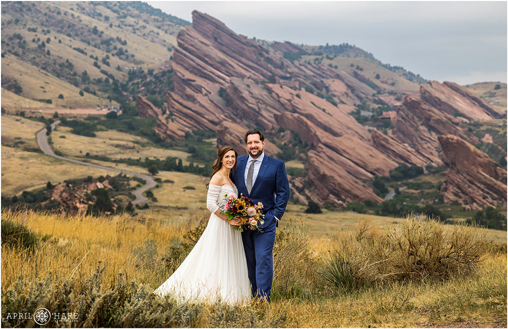 Couple pose for a classic Portrait at East Mount Falcon Trailhead with Red Rocks in the distance