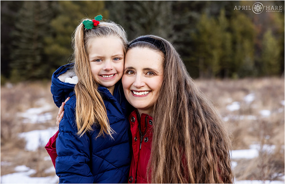 Mama with her cute 5 year old daughter pose for a photo together in the cold winter weather in Colorado