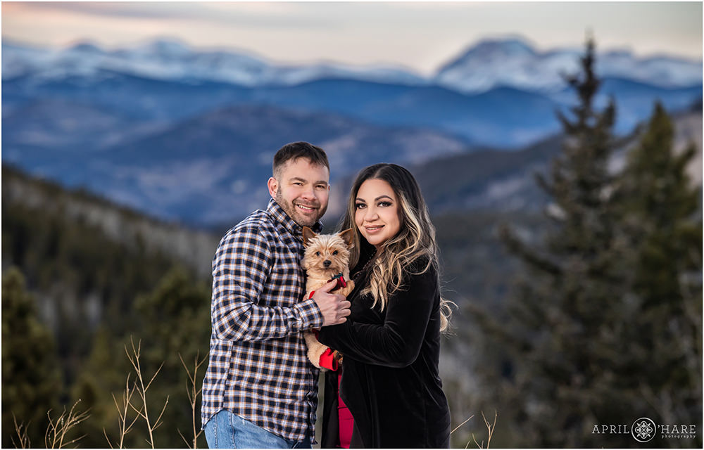Adorable couples portrait of a married couple with their sweet yorkie dog in the Colorado mountains during winter