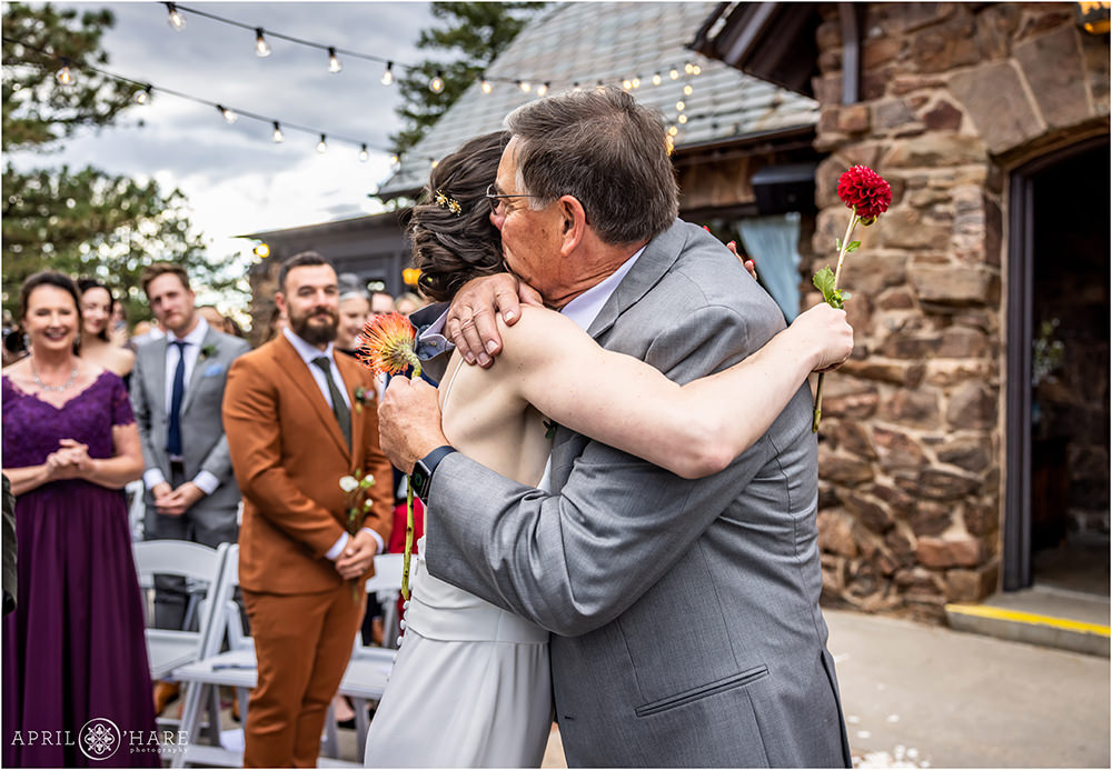 Bride and her dad hug after he walks her down the aisle at Boettcher Mansion